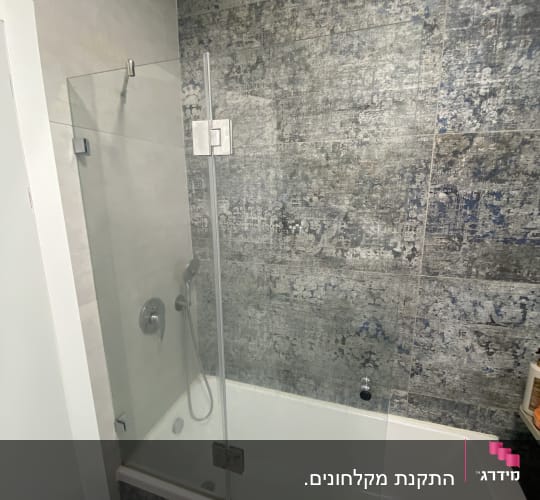 מקלחת עם דלת זכוכית ואמבטיה לבנה
